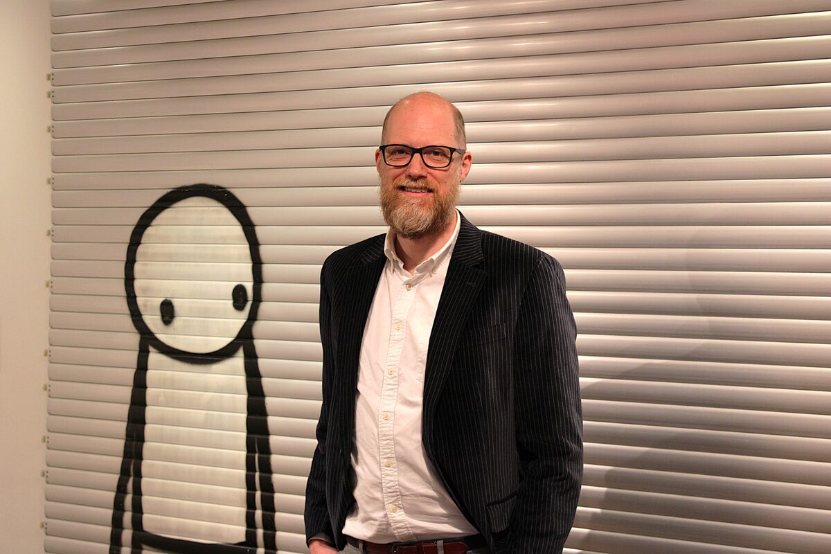 Christiaan steht vor cartoonartiger Street Art