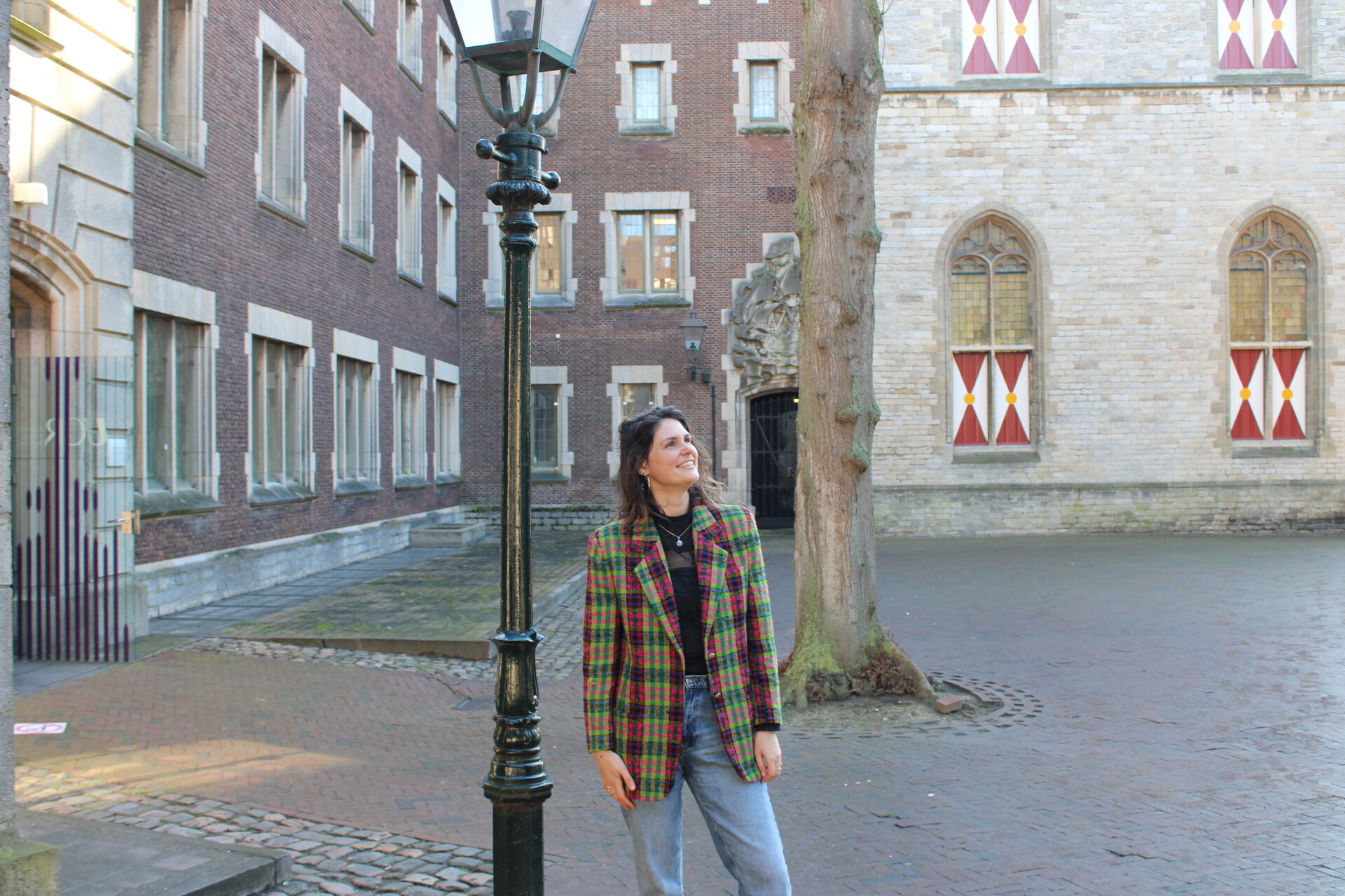 Gabriëlle blickt auf einem alten Marktplatz nach oben